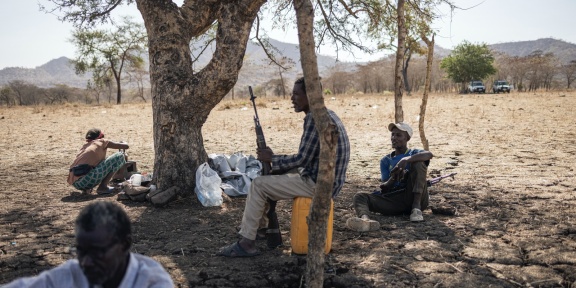 Δύο μέλη μιας τοπικής πολιτοφυλακής επιφορτισμένης με την ασφάλεια του καταυλισμού κάθονται στα περίχωρα του νεοσύστατου προσφυγικού καταυλισμού Αγουλάλα, κοντά στο Μαγκανάν, 80 χιλιόμετρα από τα σύνορα με το Σουδάν στην περιοχή Αμχάρα της Αιθιοπίας, στις 28 Φεβρουαρίου 2024.
